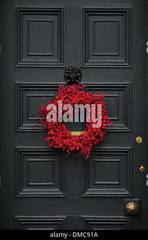 Couronne de Noël accroché sur la porte avant de l'anglais traditionnel country home, Ashford-dans-l-eau, Peak District, Derbyshire Banque D'Images