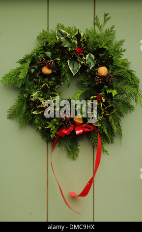 Couronne de Noël accroché sur la porte avant de l'anglais traditionnel country home, Peak District, Derbyshire Banque D'Images