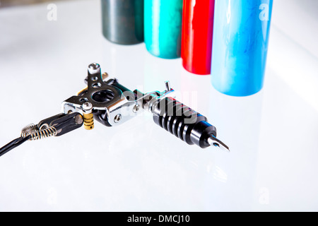 Pistolet de tatouage avec tubes d'encre sur fond blanc Banque D'Images