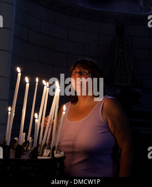 Femme en Eglise française bougies d'éclairage Banque D'Images
