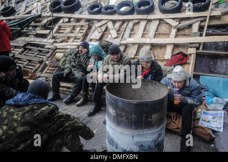 Kiev, Ukraine. 13 Décembre, 2013. Les protestataires se réchauffer près d'un feu allumé dans un tambour d'acier à un barrage à la rue principale Khreschatyk où des manifestants pro-intégration européenne, tenir un rassemblement dans le centre de Kiev le 13 décembre 2013.Photo : Pilipey NurPhoto romain/crédit : Pilipey NurPhoto/Romain/ZUMAPRESS.com/Alamy Live News Banque D'Images