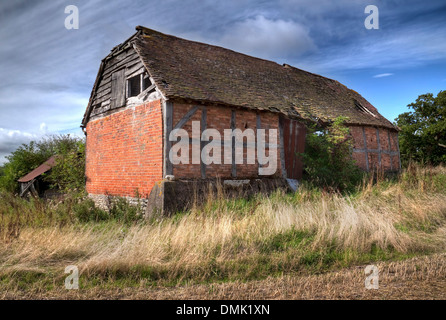 Bois et envahi par la demi-brique percé de grange, Warwickshire, en Angleterre. Banque D'Images