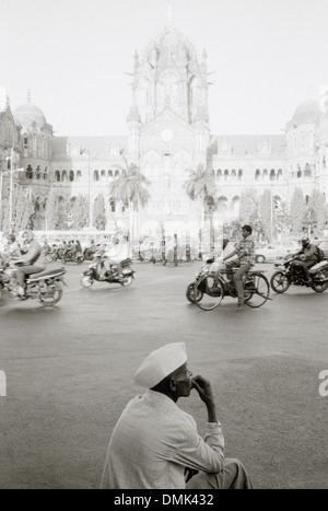 L'homme portant un chapeau de Gandhi dans l'extérieur de Victoria Chhatrapati Shivaji Terminus de Bombay Bombay dans le Maharashtra en Inde en Asie du Sud. Les Indiens de la Solitude Banque D'Images