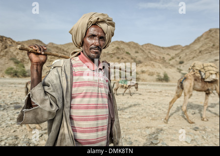 Portrait d'un homme avec ses chameaux Afar transportant le sel du désert, Berhale, Ethiopie, Afrique Banque D'Images