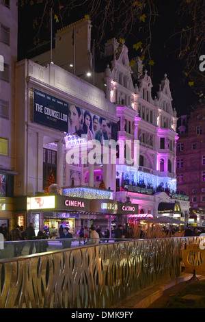 Les gens à l'extérieur des cinémas Empire et du casino éclairent et illuminent les panneaux la nuit en hiver à Leicester Square Londres West End Angleterre Royaume-Uni Banque D'Images