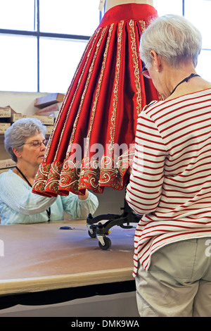 Les couturières qui travaillent sur jupe rouge pour les pêcheurs de perles, Opéra de Santa Fe, Santa Fe, Nouveau Mexique USA Banque D'Images