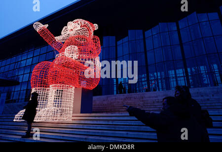 Wolfsburg, Allemagne. 14 Décembre, 2013. Les gens passent une grande Santa Clause figure faite de chaînes de lumières à Wolfsburg, Allemagne, 14 décembre 2013. L'éclairage de Noël est une partie traditionnelle de l'Avent, dans de nombreuses villes. Photo : PETER STEFFEN/dpa/Alamy Live News Banque D'Images