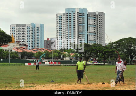 Singapour. 14 Décembre, 2013. Les travailleurs migrants indiens jouer au cricket sur le terrain près de Singapour's Race Course Road, le 15 décembre 2013. Le gouvernement de Singapour a suspendu la vente et la consommation de boissons alcoolisées dans la région de Little India le 14 décembre à 15. Credit : Puis Chih Wey/Xinhua/Alamy Live News Banque D'Images