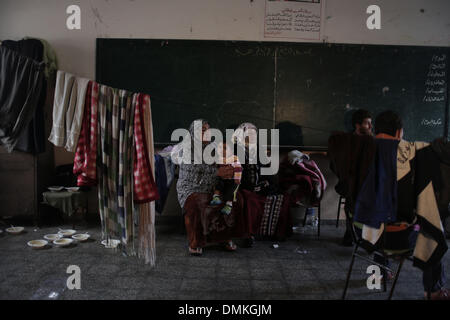 Gaza, Territoires palestiniens. Le 15 décembre 2013. Les Palestiniens s'asseoir à l'intérieur d'une école après avoir été évacués de leurs maisons qui sont inondés avec l'eau de pluie, sur un jour de tempête dans la ville de Gaza le 15 décembre, 2013. Source : Xinhua/Alamy Live News Banque D'Images