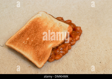 Les haricots sur toast une chute accidentelle et la création d'une tache sur tapis de sol velours beige Banque D'Images