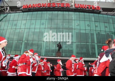 Old Trafford, Manchester, Royaume-Uni. Le 15 décembre 2013. Le passage des coureurs de rêves théâtre lors du septième fondation Manchester United Santa Run. Le Santa Run est un événement de bienfaisance avec les participants à recueillir des fonds pour la Fondation et ses partenaires de bienfaisance Francis House Children's Hospice, le Christie et l'UNICEF, ou un autre organisme de bienfaisance de choix d'un participant. Un porte-parole de la Fondation de Manchester United a déclaré que plus de 1500 coureurs ont participé. Credit : Deborah Vernon/Alamy Live News Banque D'Images