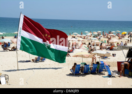 Un petit groupe de supporters de football avec leurs propres drapeaux de soutien de football tels que le drapeau Fluminense FC sur la plage d'Ipanema à Rio de Janeiro, Brésil Banque D'Images