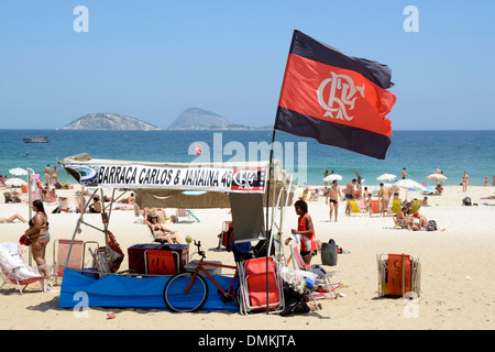 Un petit groupe de supporters de football avec leurs propres drapeaux de soutien de football tels que le drapeau Fluminense FC sur la plage d'Ipanema à Rio de Janeiro, Brésil Banque D'Images