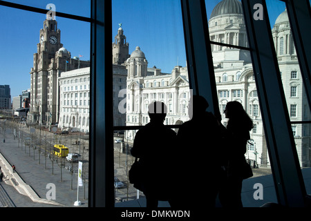 Les visiteurs à la recherche de la fenêtre du Musée de Liverpool vers Liver Building sur Pier Head, Liverpool, Merseyside, Royaume-Uni Banque D'Images