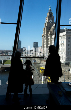 Les visiteurs à la recherche de la fenêtre du Musée de Liverpool vers Liver Building sur Pier Head, Liverpool, Merseyside, Royaume-Uni Banque D'Images