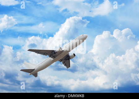 Avion dans le ciel plein de nuages moelleux Banque D'Images