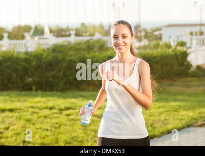 Runner - femme en marche en plein air pour la formation de marathon. Belle asiatique fit modèle de remise en forme dans la vingtaine. Tient l'eau Banque D'Images