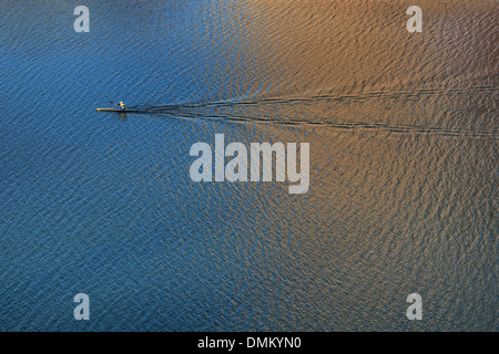 Un rameur glisse sur le lac Lady Bird à Austin. Au Texas dans l'incandescence du soir du coucher du soleil. Banque D'Images