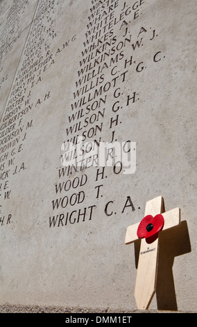 Un coquelicot, croix et les noms des soldats tombés sur la porte de Menin à Ypres, Belgique. Banque D'Images