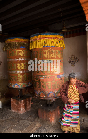 Le Bhoutan, la vallée de Bumthang, Jambey Lhakang monastère, vieux, femme de tourner les roues de prière Banque D'Images