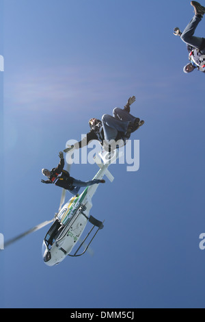 Les parachutistes Freefly sont habillés avec drôle combinaison et sortant de l'hélicoptère dans une position assis. Banque D'Images