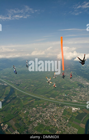 Parachutiste avec tube d'air colorés est plongée dans le bleu du ciel. Certains amis de pontage sont voler autour du tube d'air et d'avoir du plaisir. Banque D'Images