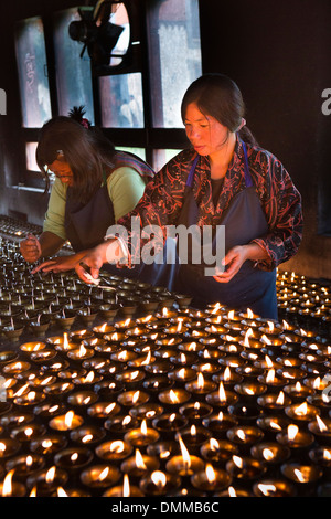 Le Bhoutan, la vallée de Bumthang, Jambey Lhakang, monastère, éclairage femme lampes à beurre Banque D'Images