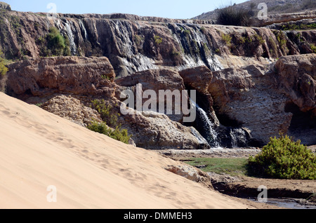 Chute d'eau et dunes de sable sur une petite vallée à proximité d'un village berbère, sur la côte au sud d'essaouira maroc Banque D'Images