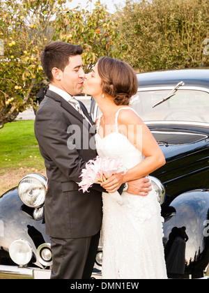 Biride et groom kissing extérieur dans une journée ensoleillée. Banque D'Images