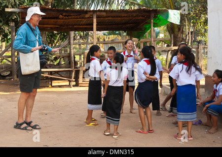 Portrait d'un horizontal de tourisme de l'Ouest avec les enfants des écoles de danse dans une école au Laos. Banque D'Images