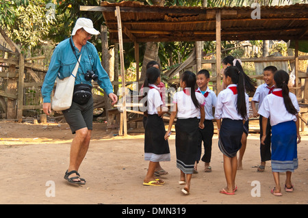 Portrait d'un horizontal de tourisme de l'Ouest avec les enfants des écoles de danse dans une école au Laos. Banque D'Images