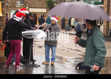 Bakewell, Derbyshire, Royaume-Uni. 14Th Dec 2013. La pluie ne parvient pas à dissuader les amuseurs de rue festive à l'exécution du marché à Bakewell Lundi du Derbyshire Peak District. Credit : Matthew Taylor/Alamy Live News Banque D'Images