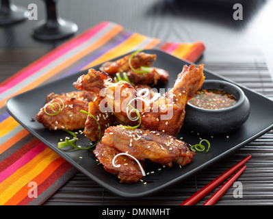 Les morceaux de poulet au barbecue cuit garnir la table dip baguettes set de table serviette de table verre verres Banque D'Images