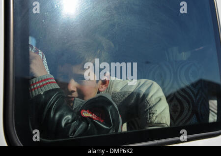 Kilis. Le 15 décembre, 2013. Un garçon regarde par la fenêtre du bus de transport à Kilis de Turquie le 15 décembre 2013. Le pouvoir turc a déclaré que le nombre de Syriens réfugiés à la Turquie a jusqu'à présent atteint 600 000 et 4000 d'entre eux ont été forcés de se déplacer vers une autre ville frontière Sanliurfa à partir d'un camp de réfugiés temporaires, en raison de la température froide et le manque de nourriture. Jusqu'à présent, 21 camps de réfugiés ont été établis à proximité des villes près de la frontière turco-syrienne. © Lu Zhe/Xinhua/Alamy Live News Banque D'Images