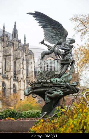 Angel sculpture dans le jardin du peuple avec l'église cathédrale de Saint John the Divine à l'arrière-plan, à New York, États-Unis Banque D'Images
