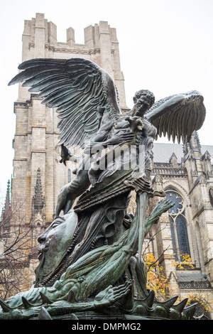 Angel sculpture dans le jardin du peuple avec l'église cathédrale de Saint John the Divine à l'arrière-plan, à New York, États-Unis Banque D'Images