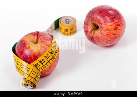 Ruban de mesure et pomme rouge isolé sur fond blanc Banque D'Images
