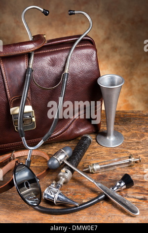 Old doctor's bag et collection de meubles anciens instruments médicaux tels que stéthoscope, marteau à réflexe et tête miroir Banque D'Images