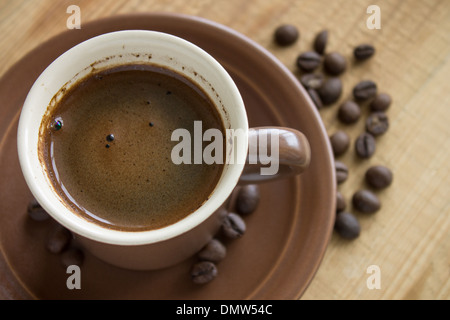 Tasse de café avec des haricots sur fond de bois Banque D'Images