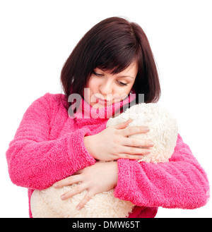 Jeune femme en peignoir Rose de câlins avec son ours en peluche Banque D'Images