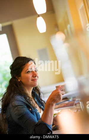 Une femme ayant une tasse de café. Banque D'Images