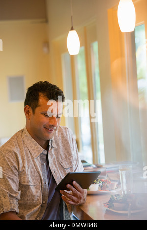 Un homme à l'aide d'une tablette numérique. Banque D'Images