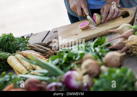 Une personne hacher les légumes et les fruits fraîchement cueillis. Banque D'Images