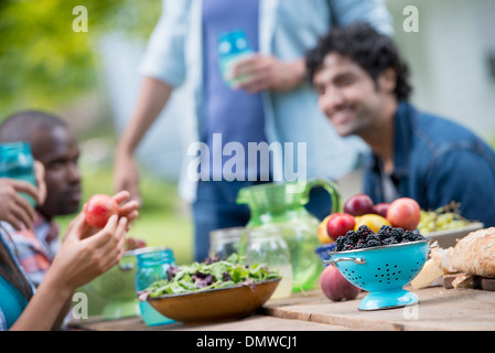 Une partie de l'été à l'extérieur. Un groupe d'amis à une table. Banque D'Images