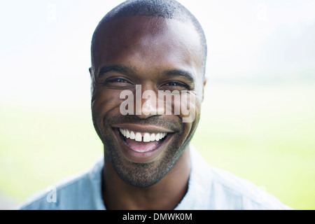 Un jeune homme en chemise bleue rire. Banque D'Images