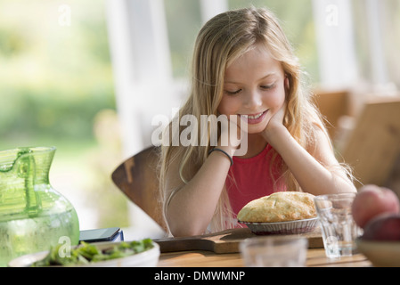 Une jeune fille à la recherche d'une pâtisserie tarte au sourire. Banque D'Images