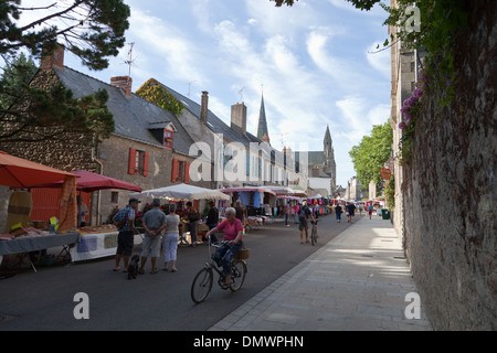 Guérande jour de marché dans la ville close, avec des stands, un cycliste passe par et shoppers Banque D'Images