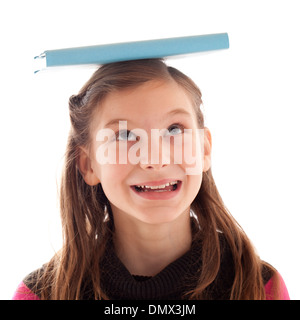 L'équilibrage de jeune fille un livre sur sa tête, isolated on white Banque D'Images