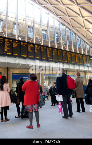 Contrôle des passagers horaires de train à la gare de Kings Cross Station, terminus de la ligne côtière est, Londres, Angleterre. Banque D'Images