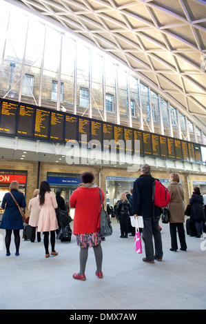 Contrôle des passagers horaires de train à la gare de Kings Cross Station, terminus de la ligne côtière est, Londres, Angleterre. Banque D'Images